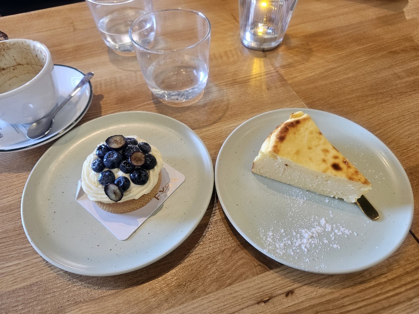 Tartelletta ai mirtilli, cheesecake e cappuccino sul tavolo di FYSA